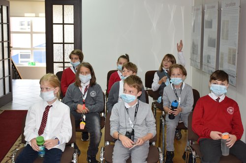 Grupa dzieci siedzi na krzesłach